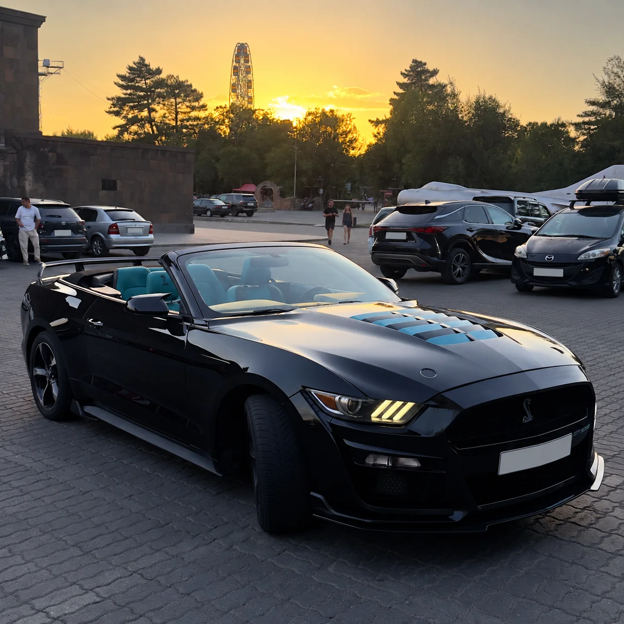 Чёрный Mustang с открытой крышей на закате